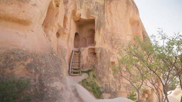 Wood ladder entrance to manmade rock cave dwelling Cappadocia landscape