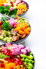 Vegan buddha bowls set with pumpkin, quinoa, tomatoes, spinach, avocado, radish, soybeans, edamame, tofu, cabbage and seeds, white background, top view. Autumn or winter winter menu, slow comfort food