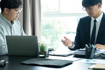 Businessmen working together at desk.