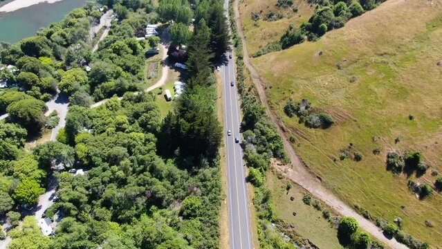 Video footage of a beautiful countryside, connected by traveled roads, and a blue lake by side. Shot was taken from top view in Bodega bay and Gualala coast, California.