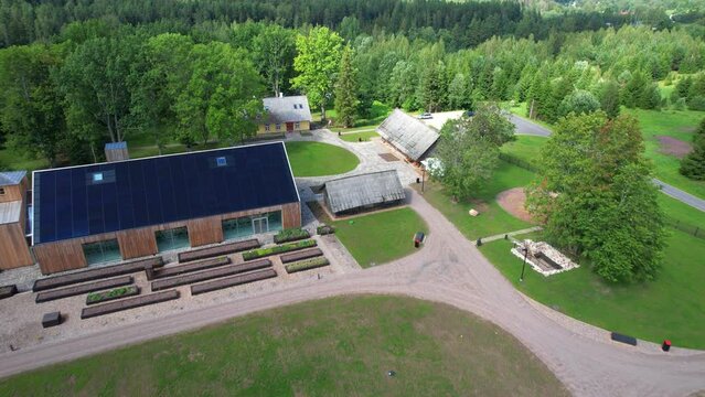 drone flight over old wooden farm in Valgamaa over green summer forests