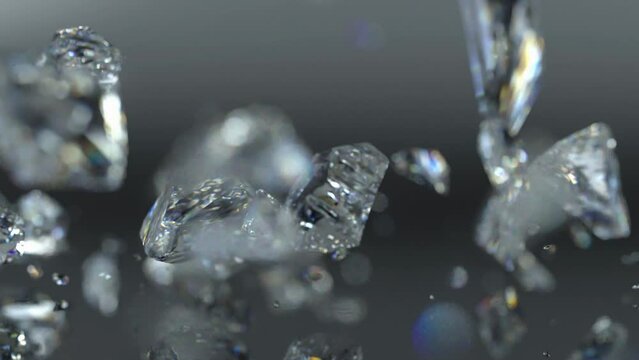 Diamond-shaped crystal falling fast on a rough surface and shattering to pieces in slow motion