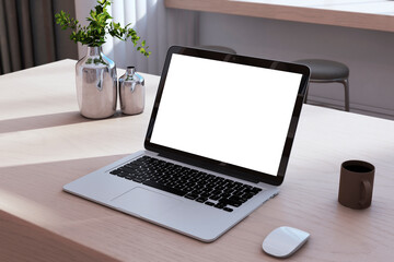 Fototapeta premium Close u of creative designer desktop with empty white mock up laptop computer screen, coffee cup, other items. 3D Rendering.