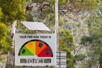 Solar powered fire danger status and bush fire risk sign installed on public road side showing high...