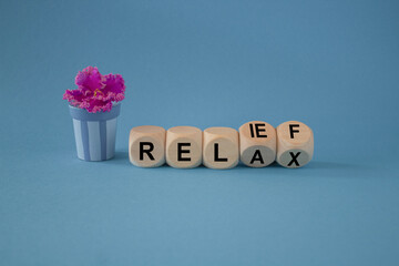 Relax and reset symbol. Turned wooden cubes and changes the word relax to reset. Beautiful blue...
