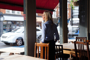 Contemplative owner looking through window at coffee shop
