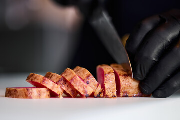 Cooking fish dishes in the restaurant. The chef cuts the dance before serving to the customer