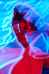 Portrait with long exposure. Young man, calm guy posing in futuristic digital projector reflection...