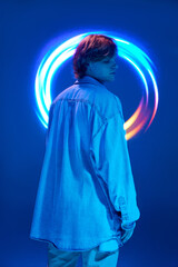rear view portrait of young attractive man posing in neon lights and vivid colors illuminated vivid...