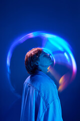 Sie view of young attractive man enjoying atmosphere in neon colorful light and illuminated vivid...