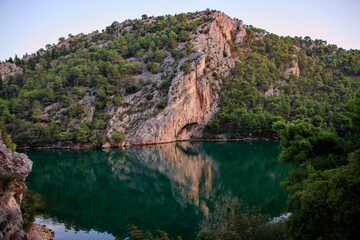 A view to the rocks with reflection in the calm river at national park Krka, Croatia