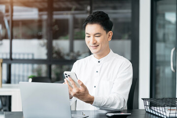 Businessman sitting at table using mobile phone, online working on laptop, searching the information on internet network.