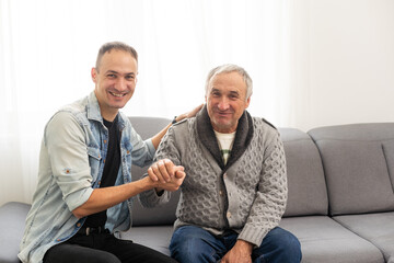 Portrait of happy smiling father and his adult son. Man hugging his elderly father. Father's day concept.