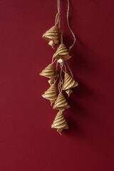 Bells made out of straw on a red background. Straw bells decorations.