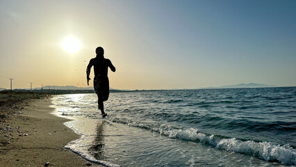 person jogging, exercising and walking on the beach at sunrise © emerald_media