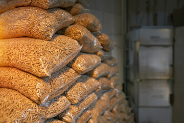 Wooden pellets stacked in plastic bags, ready to be used for heating a house in winter, an alternative and sustainable source of fuel.