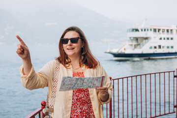 Happy brunette 30s woman enjoying summer holidays. Concept of vacation. Varenna, Italy. Lake Como....