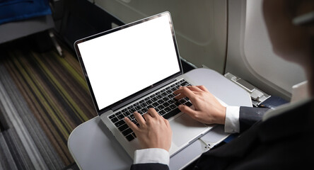 Business woman plane passenger using mock up laptop on board for working while sitting in airplane....