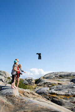 Girls throwing boot on rocks