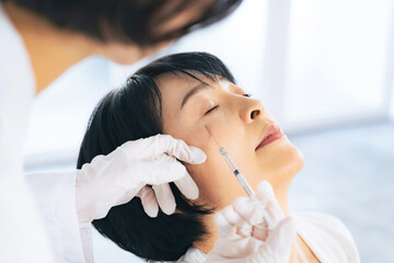 顔に注射を受ける女性　美容整形　ヒアルロン酸　ボトックス注射