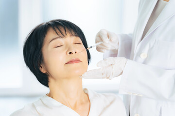 顔に注射を受ける女性　美容整形　ヒアルロン酸　ボトックス注射