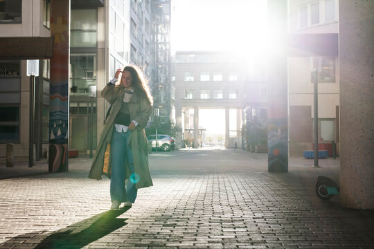 Young woman walking in city at sunset