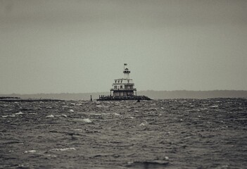 Majestic lighthouse on a rocky shoreline, overlooking a tranquil body of water