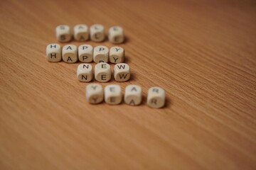 inscription made of wooden cubes happy new year sale on the table close-up with free space for text insertion