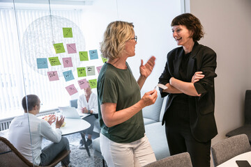 Coworkers brainstorming on window in office