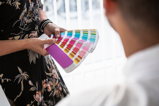 Woman showing paint swatches to colleague in office