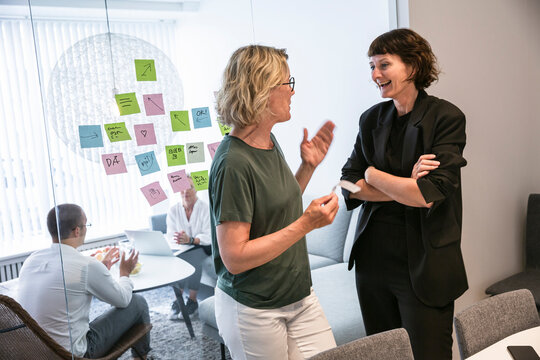 Coworkers brainstorming on window in office