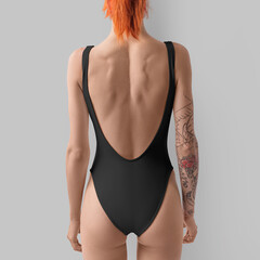 Mockup of a black sports swimsuit on a slender red-haired girl, women's swimwear for design,...