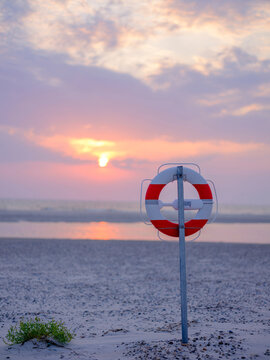 Life preserver on beach during sunset