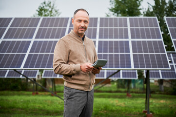Male investor counting his future income from alternative energy investment. Confident man...