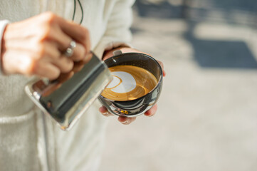 closeup hand doing hot latte art coffee