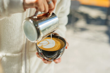 closeup hand doing hot latte art coffee