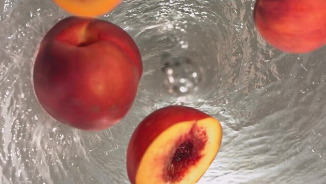 Super Slow Motion Shot of Fresh Peaches Falling into Water Whirl