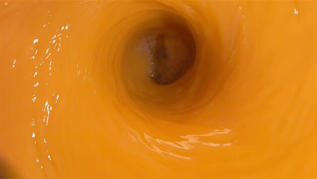 Super Slow Motion Shot of Fresh Peaches Falling into Juice Whirl