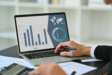 Closeup male analyst using laptop, working with marketing research results or statistics data at...