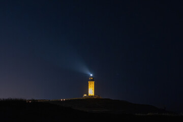 Naklejka na ściany i meble Guiding Light: The Majestic Lighthouse Against the Night Sky