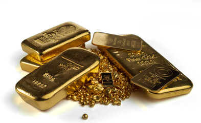 Several gold bars of different weights and a pile of gold granules. Selective focus. Isolated on a...