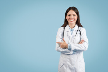 Woman doctor pointing to the side at free space and smiling