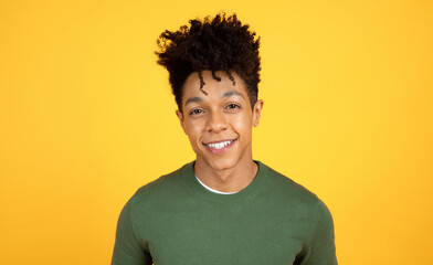 Portrait of smiling young black guy hipster posing on yellow