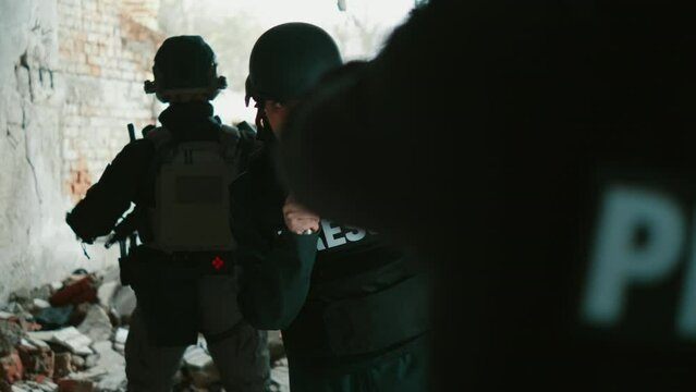 Female journalist reporting live in a destroyed building in a war zone
