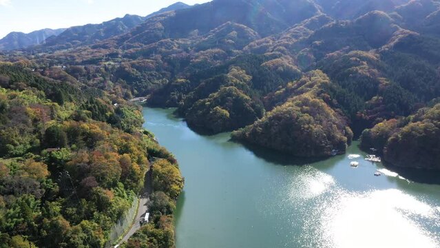 Images of mountains in autumn color in Japan, autumn leaves, etc. Drone image of Lake Sagami in Japan with road.