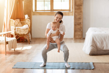 Young mom exercising with her baby boy at home
