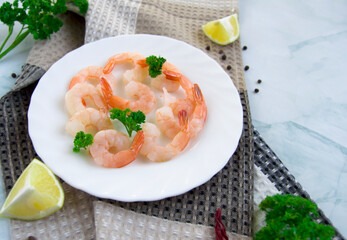 Boiled delicious shrimp with lemon and lime on marble background. Granite background. Selective focus.