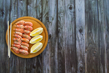 Delicious shrimp with lime and citrus. Wooden background.