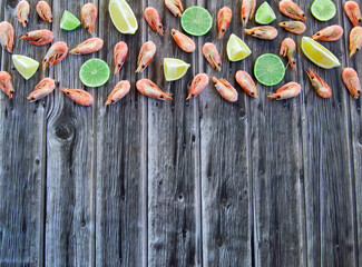 Delicious shrimp with lime and citrus. Wooden background.