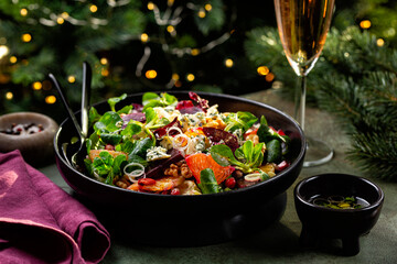 Christmas or New Year table with food. Winter salad with beetroot, oranges, walnuts, pomegranate,...
